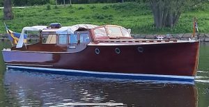 Trämotorbåt med salongsöverbyggnad.