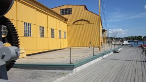 Stor nyuppförd byggnad vid en träbrygga.