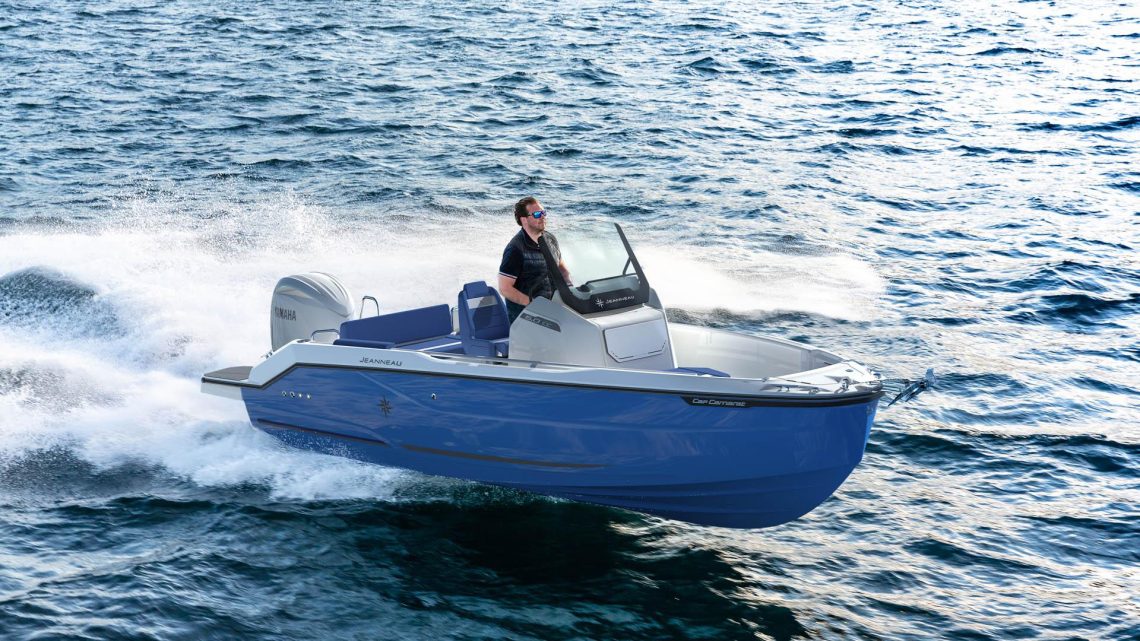 Mindre motorbåt i planande gång på vatten. En man med solglasögon vid ratten.