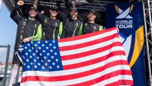 Fyra män på en scen. I händerna håller de en stor amerikansk flagga.