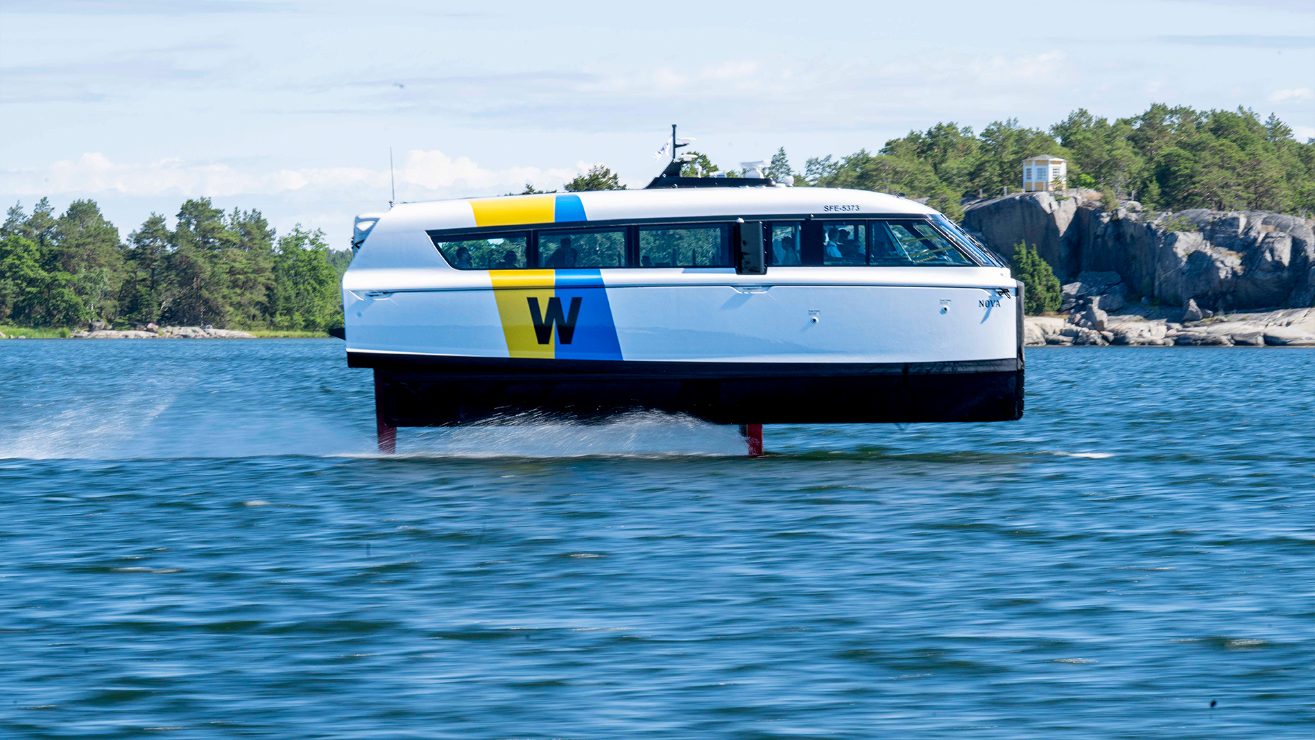 En liten färja på bärplan som forsar fram i skärgården.