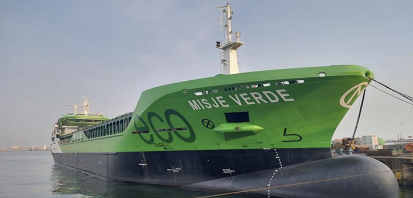 Ett lastfartyg, grönfärgat, med stor bulbköl. På skrovet står "Misje Verde".